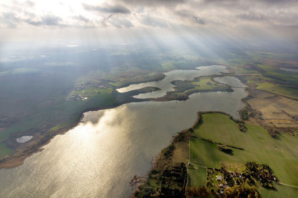 Luftbild Güstrow - Sonnenstrahlen über herbstlich wolkenverhüllter Seenlandschaft Güstrow im Bundesland Mecklenburg-Vorpommern