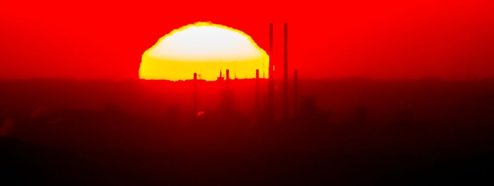 Luftbild Gelsenkirchen - Sonnenuntergang mit Rauchschwaden und Silhouette des Kraftwerk Scholven vor blauem Himmel in Gelsenkirchen im Bundesland Nordrhein-Westfalen