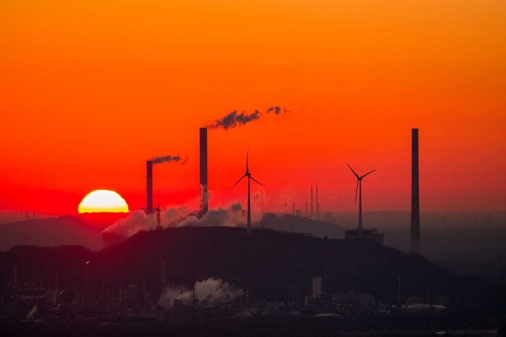 Luftaufnahme Gelsenkirchen - Sonnenuntergang mit Rauchschwaden und Silhouette des Kraftwerk Scholven vor blauem Himmel in Gelsenkirchen im Bundesland Nordrhein-Westfalen