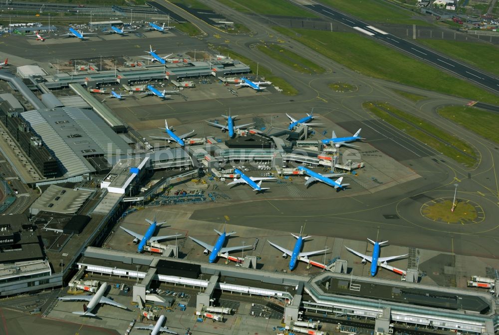 Luftbild Schiphol - Stillgelegte KLM- Passagierflugzeuge an den Terminals auf dem Gelände des Flughafen in Schiphol in Noord-Holland, Niederlande