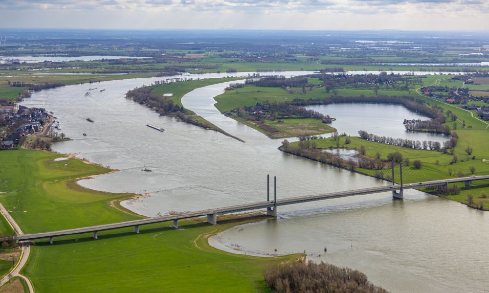 Rees aus der Vogelperspektive: Uferbereiche mit durch Hochwasser- Pegel überfluteten Flußbett an der Rheinbrücke der Bundesstraße B67 in Rees im Bundesland Nordrhein-Westfalen
