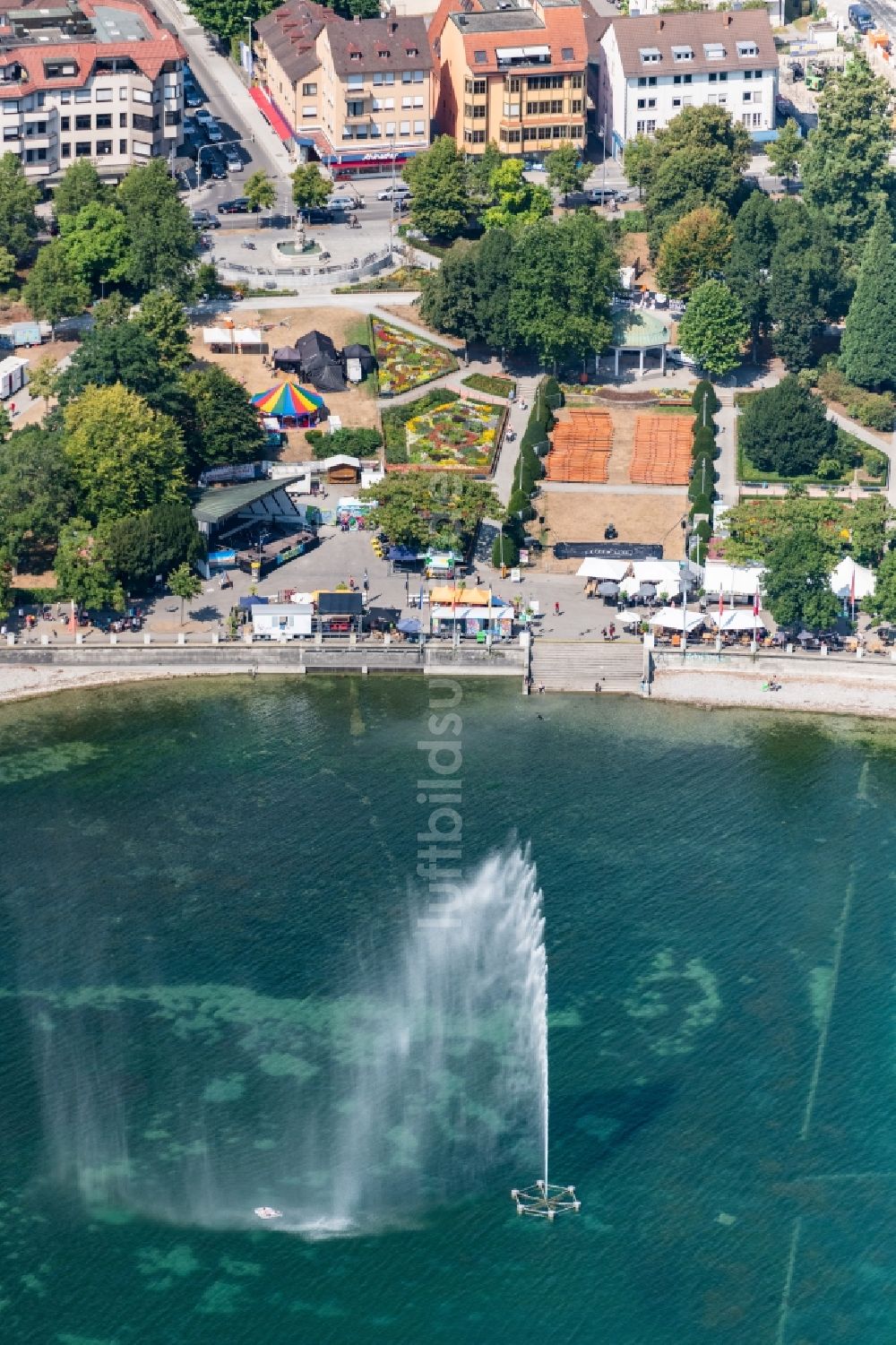 Luftaufnahme Friedrichshafen - Uferbereiche des Sees Bodensee im Vordergrund sieht man eine Wasserfontäne in Friedrichshafen im Bundesland Baden-Württemberg, Deutschland