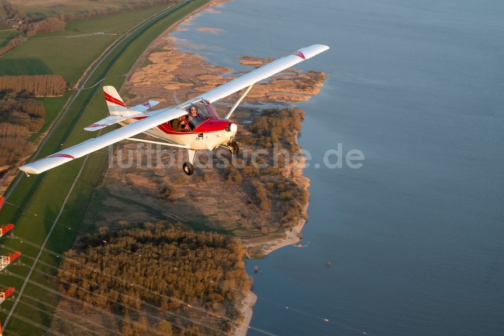 Luftaufnahme Hetlingen - Ultraleicht- Flugzeug FK9 im Fluge über dem Luftraum des Ufers der Elbe in Hetlingen im Bundesland Schleswig-Holstein, Deutschland