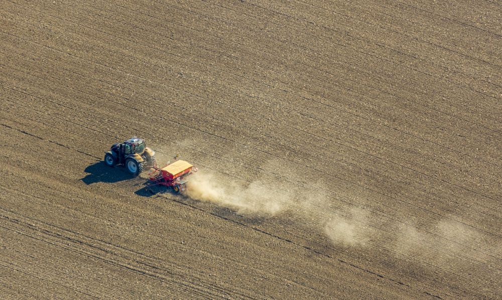 Luftbild Gehrden - Umpflugarbeiten und Umschichtung der Erde durch einen Traktor mit Pflug auf landwirtschaftlichen Feldern in Gehrden im Bundesland Nordrhein-Westfalen, Deutschland