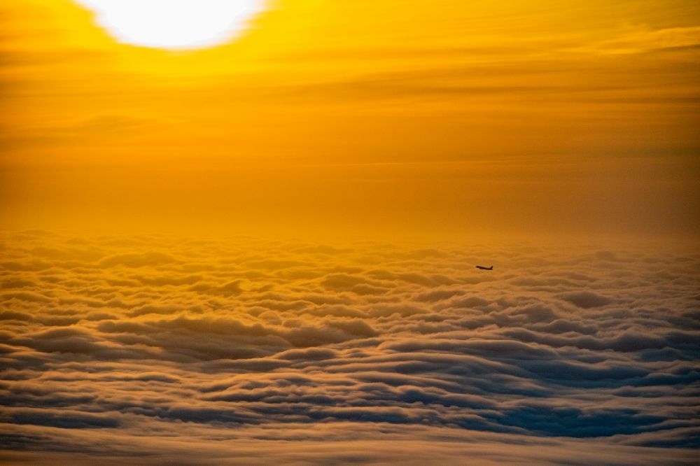 Luftbild Norderstedt - Verkehrsflugzeug im Sonnenaufgang über den Wolken nach Start in Hamburg Fuhlsbüttel in Höhe Norderstedt im Bundesland Schleswig-Holstein Deutschland
