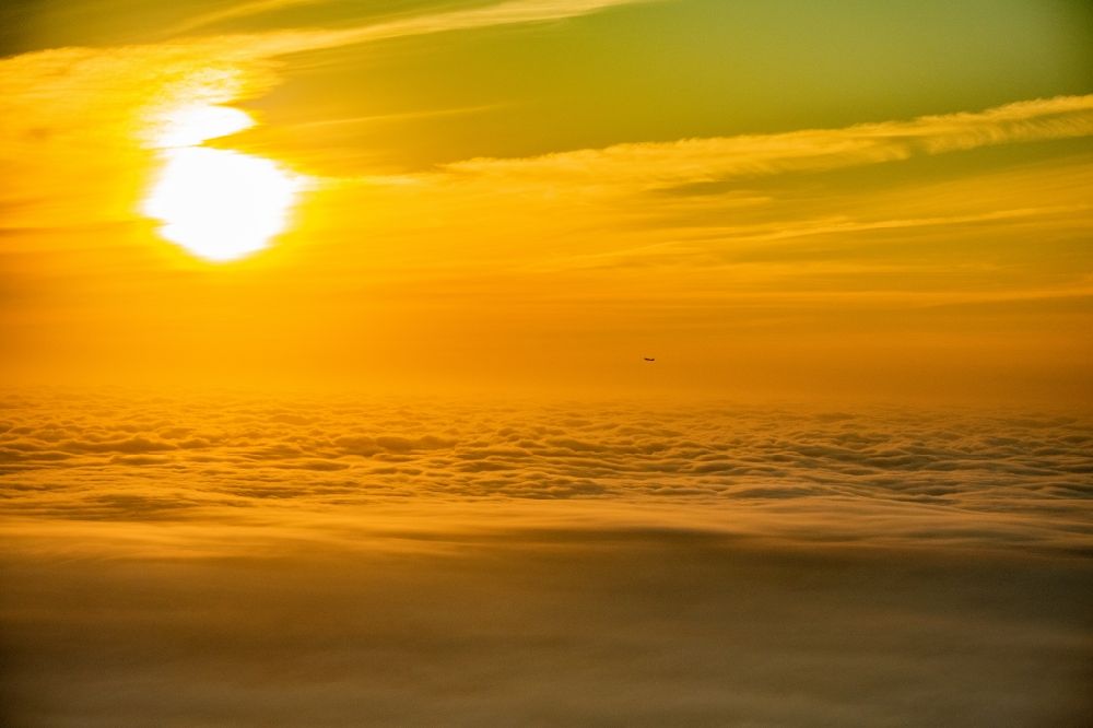 Luftbild Norderstedt - Verkehrsflugzeug im Sonnenaufgang über den Wolken nach Start in Hamburg Fuhlsbüttel in Höhe Norderstedt im Bundesland Schleswig-Holstein Deutschland