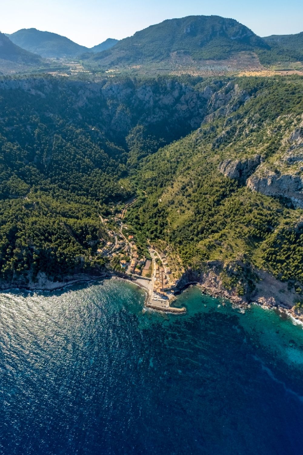 Luftaufnahme Valldemossa - Von Wald umgebene Ortsansicht an der Meeresküste am Port de Valldemossa in Valldemossa in Balearische Insel Malorca, Spanien