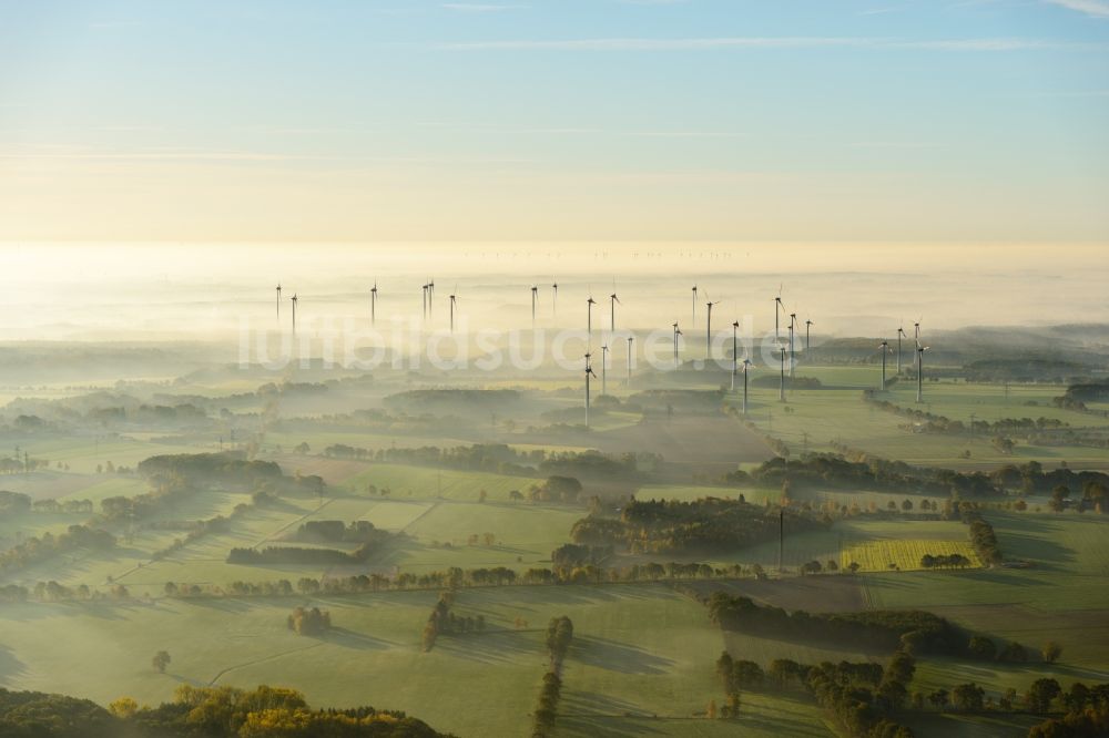 Luftaufnahme Deinste - Wetterbedingt in eine Nebel- Schicht eingebettete Windenergieanlagen auf einem Feld in Deinste im Bundesland Niedersachsen, Deutschland