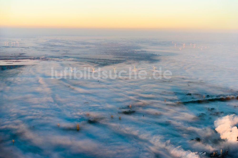 Luftaufnahme Stade - Wetterbedingt in eine Nebel- Schicht eingebettete Windenergieanlagen auf einem Feld in Stade im Bundesland Niedersachsen, Deutschland