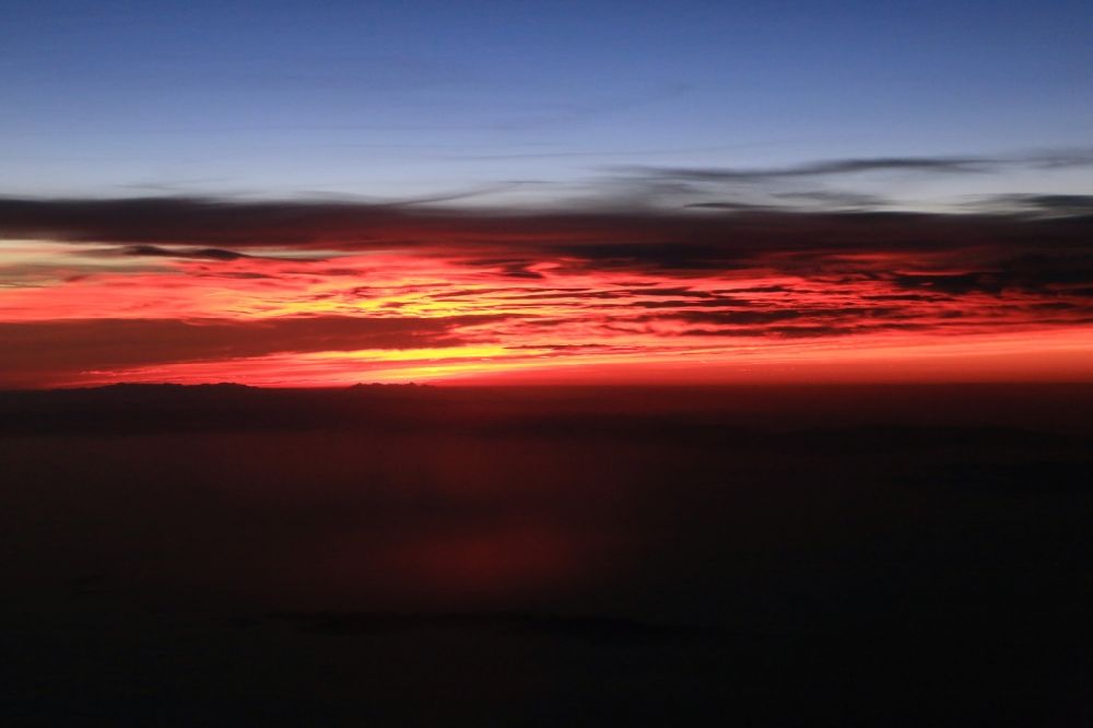Luftbild Aime - Wetterlage mit Wolkenbildung und Lichtreflektionen bei Sonnenaufgang über der Gebirgsgruppe der Seealpen in Aime in Auvergne-Rhone-Alpes, Frankreich