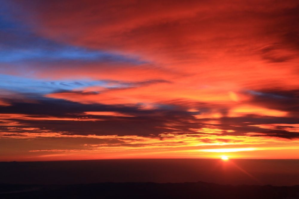 Aime von oben - Wetterlage mit Wolkenbildung und Lichtreflektionen bei Sonnenaufgang über der Gebirgsgruppe der Seealpen in Aime in Auvergne-Rhone-Alpes, Frankreich
