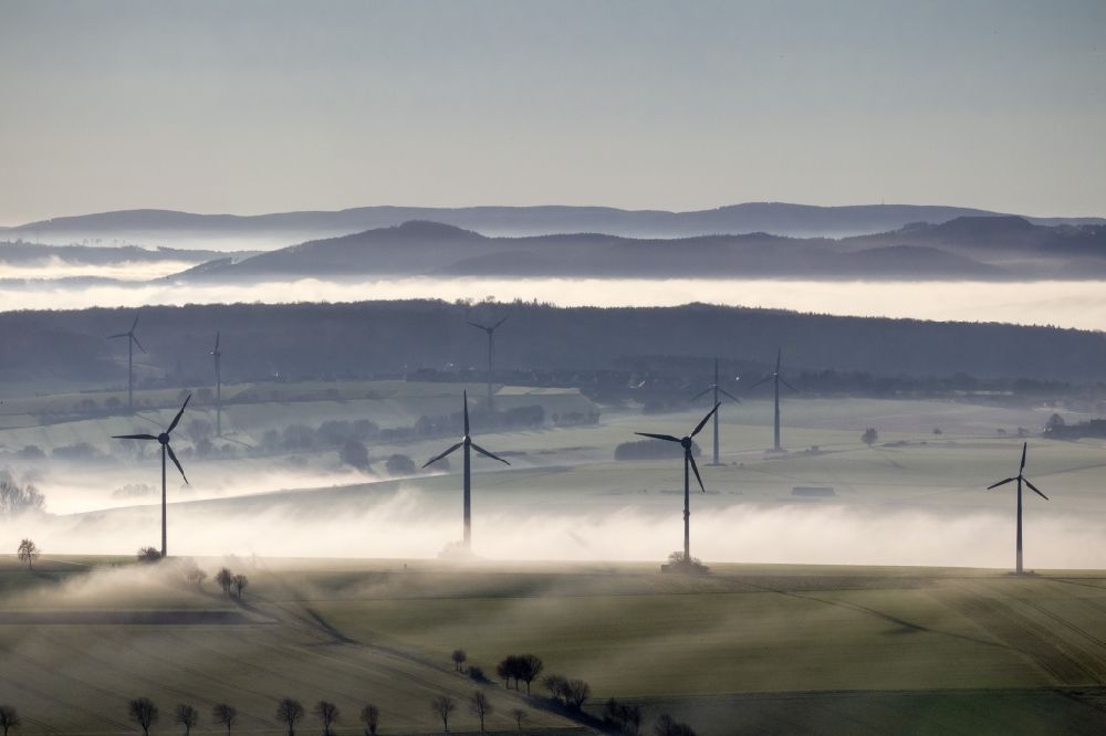 Ense aus der Vogelperspektive: Windräder eines aus Nebel- Schicht und Wolken herausragenden Windkraftwerkes bei Ense im Sauerland in Nordrhein-Westfalen NRW