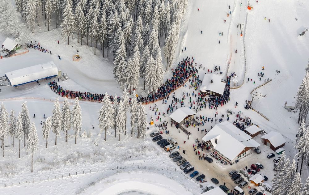 Luftaufnahme Winterberg - Winter - Blick auf die mit Schnee bedeckter Skipiste und Abfahrtskigelände mit Apres-Ski - Raststätte in Winterberg im Bundesland Nordrhein-Westfalen NRW