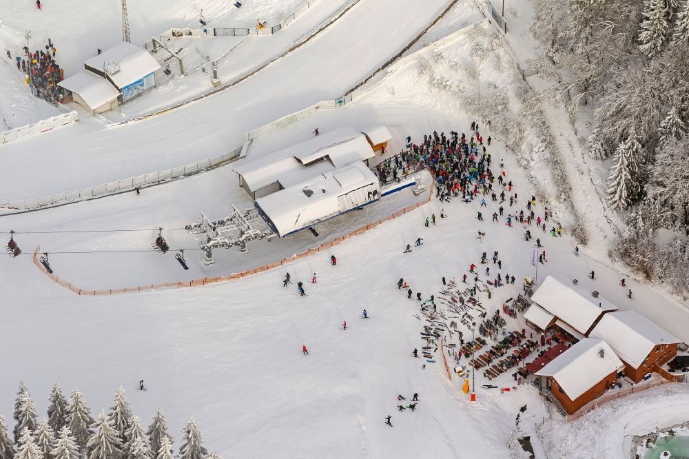 Luftbild Winterberg - Winter - Blick auf die mit Schnee bedeckter Skipiste und Abfahrtskigelände mit Apres-Ski - Raststätte in Winterberg im Bundesland Nordrhein-Westfalen NRW