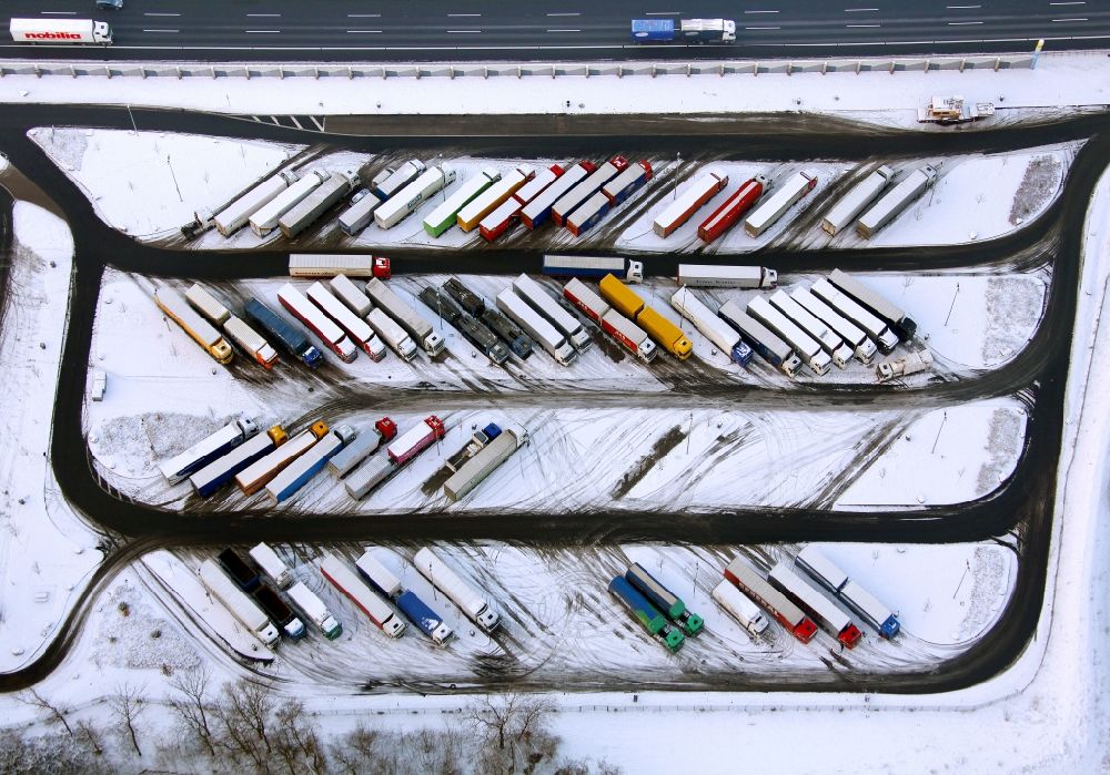 Hamm aus der Vogelperspektive: Winter - Landschaft des mit Schnee bedeckten LKW- Parkplatz an der Raststätte Hamm, einem gern für Lenkzeiten - Pausen im Güterverkehr genutzten Rastplatz in Hamm in Nordrhein-Westfalen