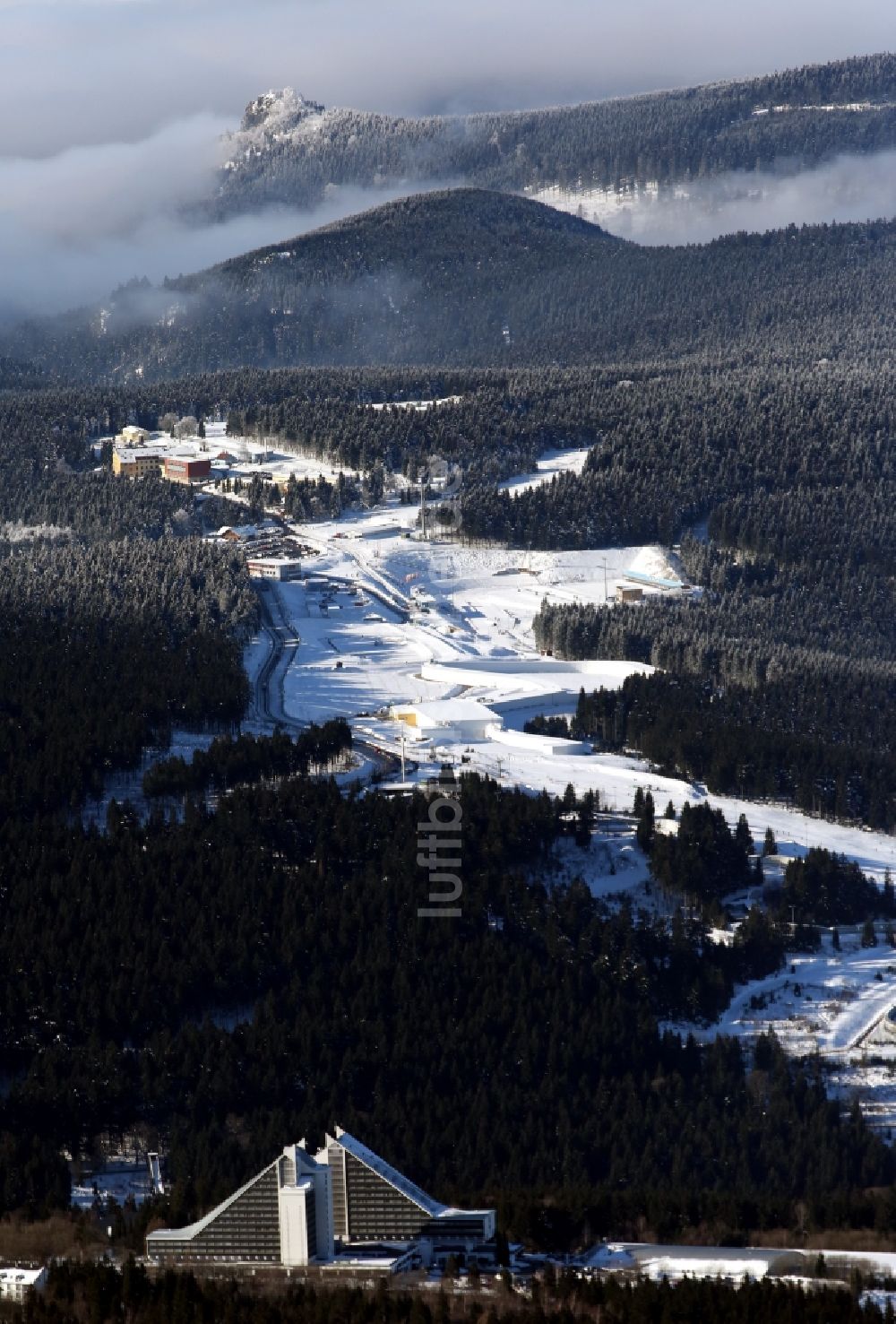 Oberhof von oben - Winterlandschaft der mit Schnee bedeckten Skibahn mit der Skihalle und Hotel Panorama in Oberhof im Bundesland Thüringen