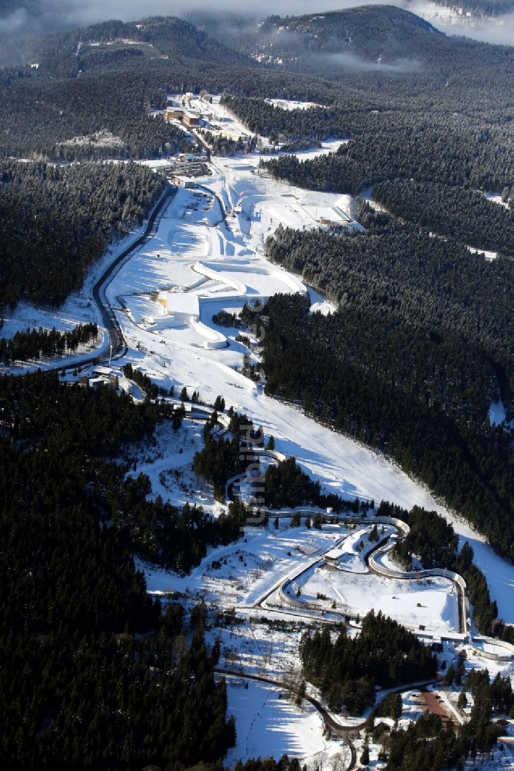 Luftaufnahme Oberhof - Winterlandschaft der mit Schnee bedeckten Skibahn mit der Skihalle in Oberhof im Bundesland Thüringen