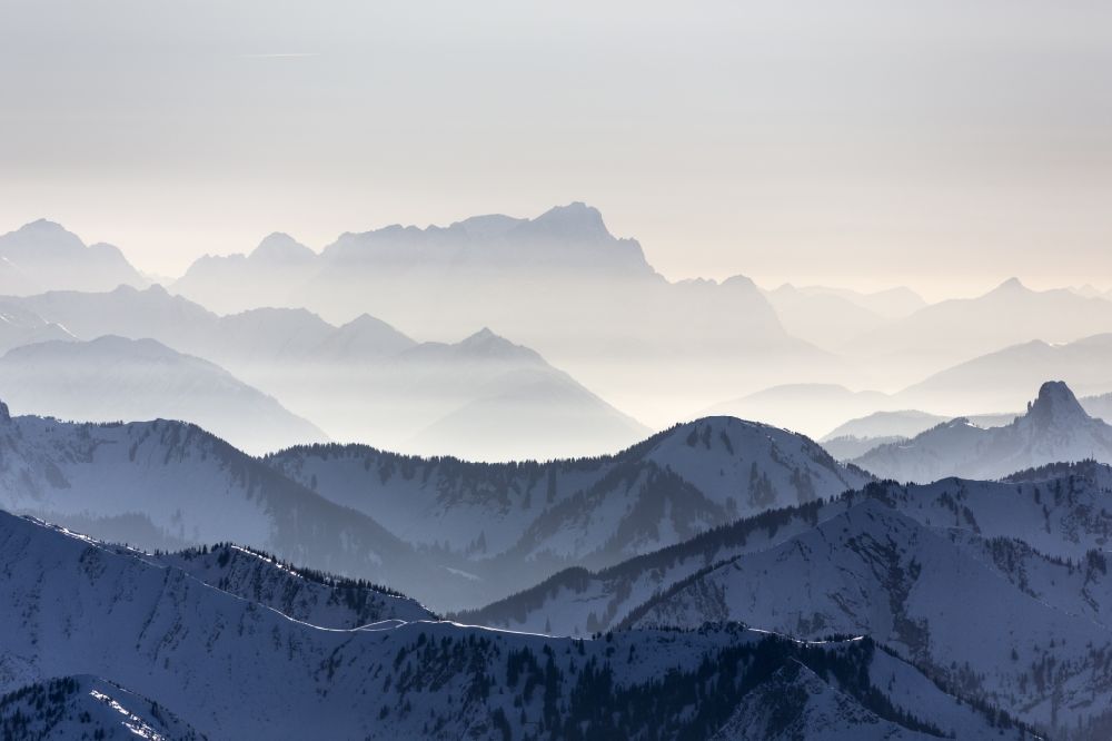 Garmisch-Partenkirchen aus der Vogelperspektive: Winterlich mit Schnee bedeckte Landschaft vom Mangfallgebirge mit der Zugspitze im Hintergrund bei Garmisch-Partenkirchen im Bundesland Bayern