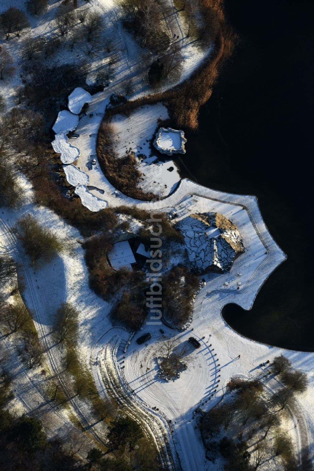 Berlin aus der Vogelperspektive: Winterlich schneebedeckte Uferbereiche des Sees Hauptsee im Erholungspark Britzer Garten in Berlin