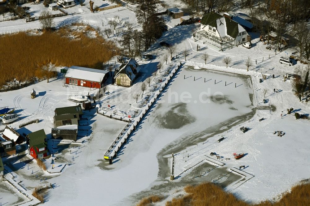 Luftbild Ahrenshoop - Winterluftbild Bootshaus- Reihen mit Sportboot- Anlegestellen und Bootsliegeplätzen am Uferbereich des Saaler Bodden in Ahrenshoop im Bundesland Mecklenburg-Vorpommern