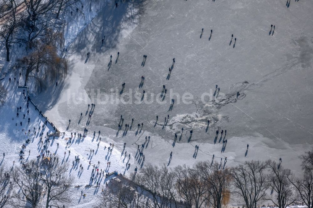 Luftaufnahme Münster - Winterluftbild Eis- Spaziergänger auf dem zugefrorenen Seeoberfläche des Aasee in Münster im Bundesland Nordrhein-Westfalen, Deutschland