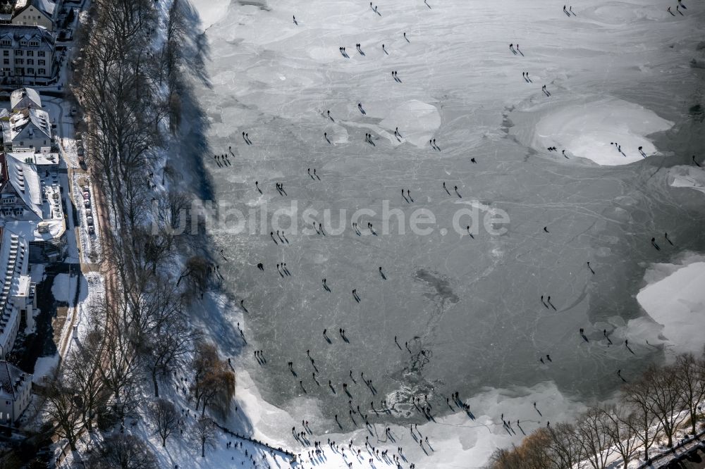 Münster aus der Vogelperspektive: Winterluftbild Eis- Spaziergänger auf dem zugefrorenen Seeoberfläche des Aasee in Münster im Bundesland Nordrhein-Westfalen, Deutschland