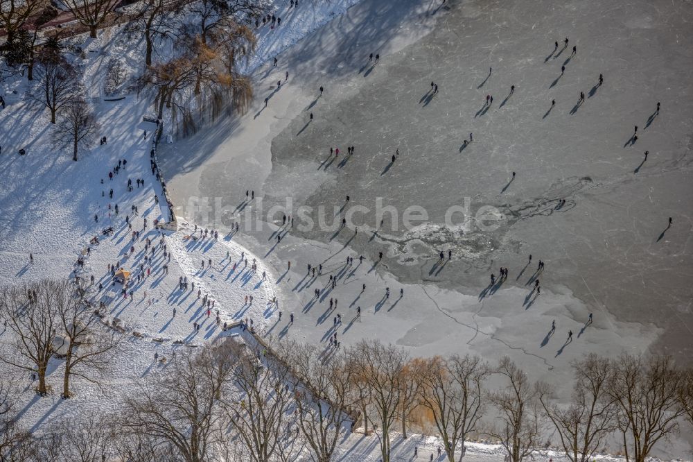 Luftaufnahme Münster - Winterluftbild Eis- Spaziergänger auf dem zugefrorenen Seeoberfläche des Aasee in Münster im Bundesland Nordrhein-Westfalen, Deutschland