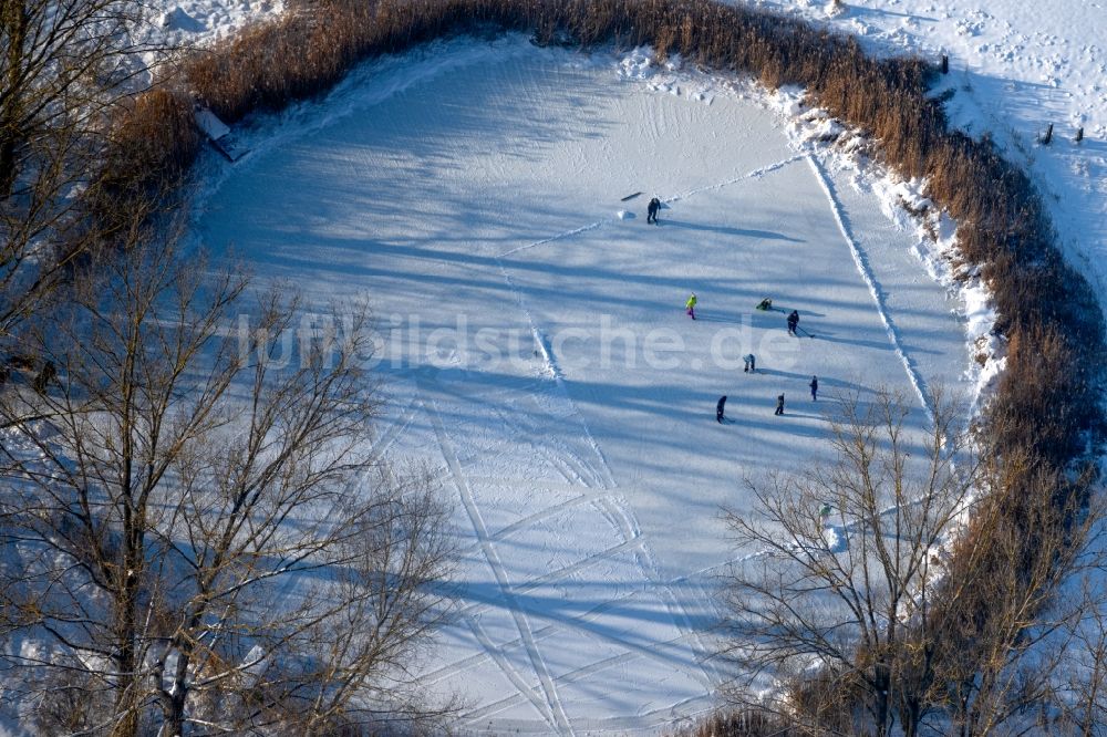 Luftbild Südharz - Winterluftbild Eis- Spaziergänger auf dem zugefrorenen Seeoberfläche Der kleine See mit Eishockey - Spielern in Südharz im Bundesland Sachsen-Anhalt, Deutschland