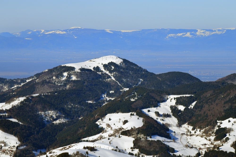 Schönenberg von oben - Winterluftbild. Schneebedeckter Gipfel des Belchen im Südschwarzwald bei Schönenberg im Bundesland Baden-Württemberg, Deutschland und Blick zu den Vogesen in Frankreich