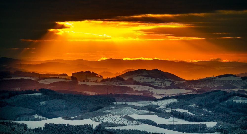 Luftaufnahme Winterberg - Winterluftbild Sonnen- Untergang über der Landschaft am Rothaargebirge in Winterberg im Bundesland Nordrhein-Westfalen, Deutschland