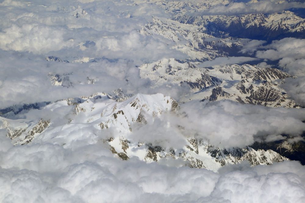 Luftaufnahme Chamonix-Mont-Blanc - Wolken über der schneebedeckten Felsen- und Berglandschaft beim Mont-Blanc in Chamonix-Mont-Blanc in Auvergne-Rhone-Alpes, Frankreich
