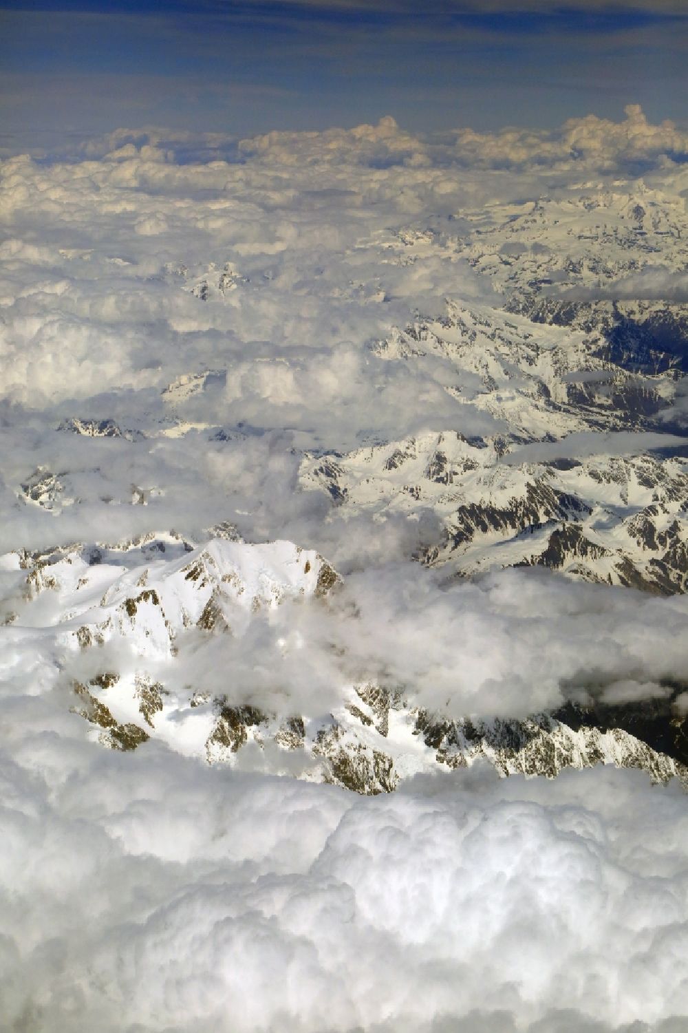 Chamonix-Mont-Blanc von oben - Wolken über der schneebedeckten Felsen- und Berglandschaft beim Mont-Blanc in Chamonix-Mont-Blanc in Auvergne-Rhone-Alpes, Frankreich