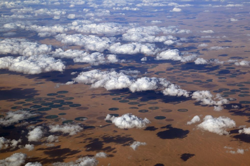 Luftaufnahme Meegowa - Wüste- Wolken- und kreisförmige Bewässerungsanlagen in der Landschaft der Wüste bei Meegowa in Al Jowf, Saudi-Arabien