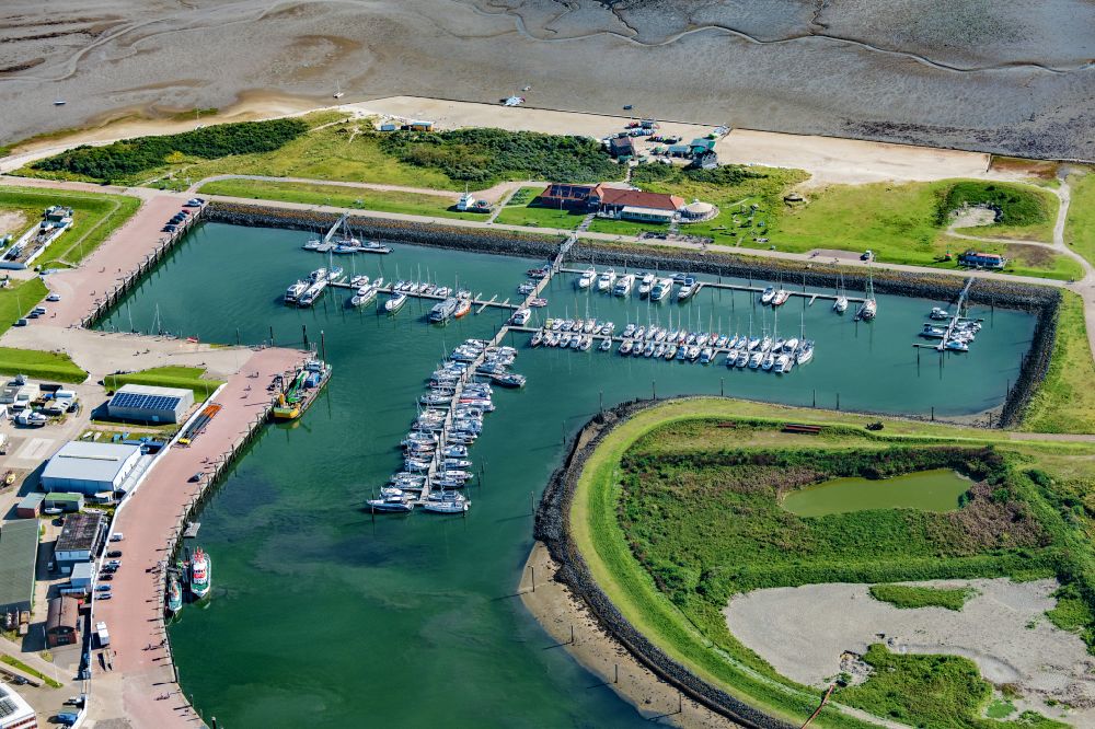 Luftaufnahme Norderney - Yachthafen mit Sportboot- Anlegestellen und Bootsliegeplätzen am Uferbereich in Norderney im Bundesland Niedersachsen, Deutschland