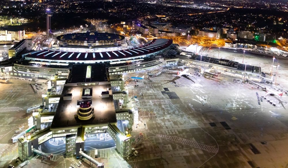 Nacht-Luftaufnahme Düsseldorf - Nachtluftbild Abfertigungs- Gebäude und Terminals auf dem Gelände des Flughafen in Düsseldorf im Bundesland Nordrhein-Westfalen, Deutschland