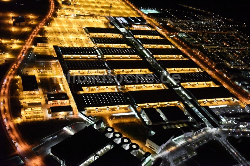 München bei Nacht aus der Vogelperspektive: Nachtluftbild der beleuchten Ausstellungshallen am Messegelände München im Bundesland Bayern