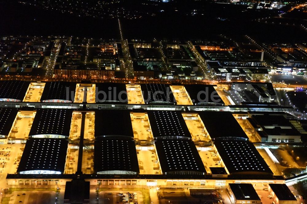 München bei Nacht von oben - Nachtluftbild der beleuchten Ausstellungshallen am Messegelände München im Bundesland Bayern