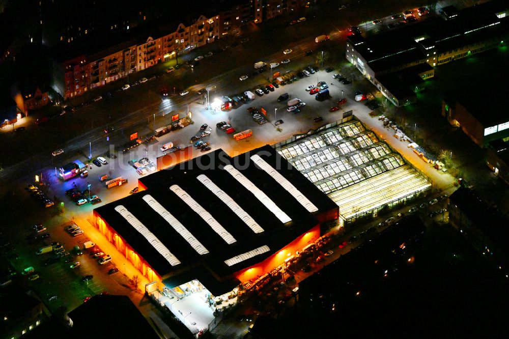 Berlin bei Nacht aus der Vogelperspektive: Nachtluftbild Gebäude des Baumarktes OBI Markt Berlin-Spandau in Berlin, Deutschland
