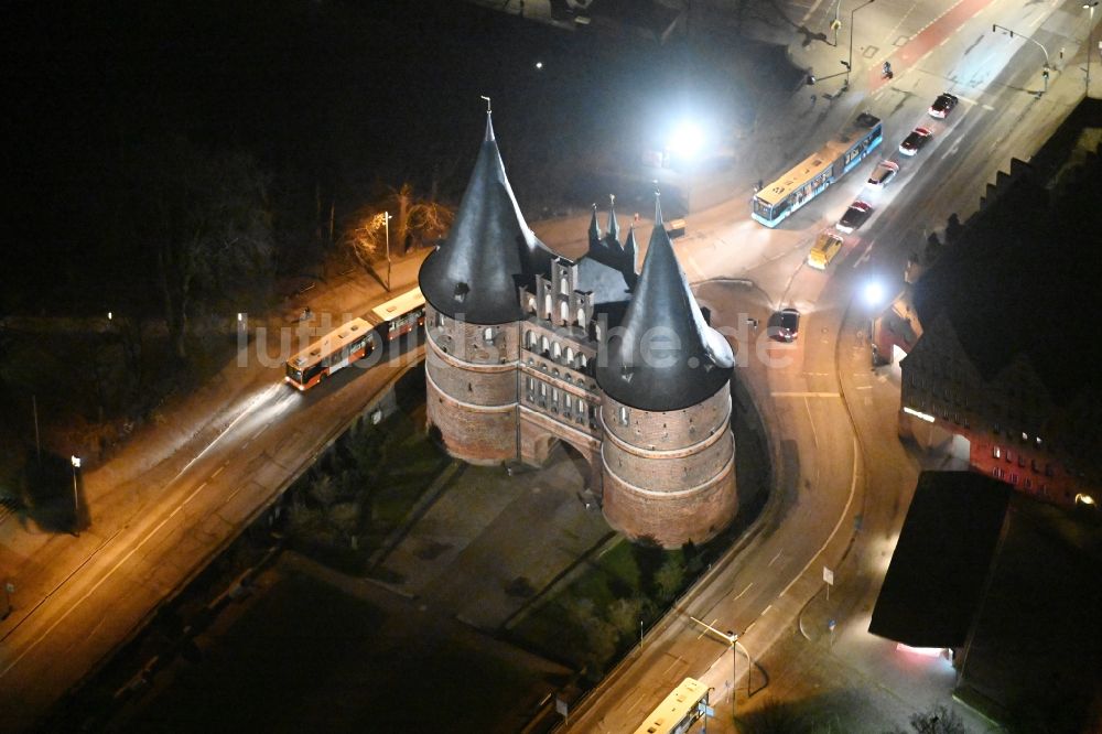 Lübeck bei Nacht aus der Vogelperspektive: Nachtluftbild Museums- Gebäude- Ensemble Museum Holstentor in Lübeck im Bundesland Schleswig-Holstein