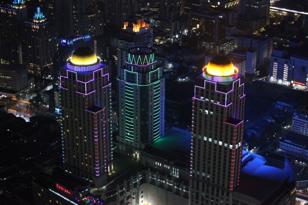 Nacht-Luftaufnahme Bangkok - Nachtaufnahme der beleuchteten Dach- Kuppeln der Hochhaus- Türme des Pratunam-Einkaufcenters im Zentrum der Stadt Bangkok in Thailand