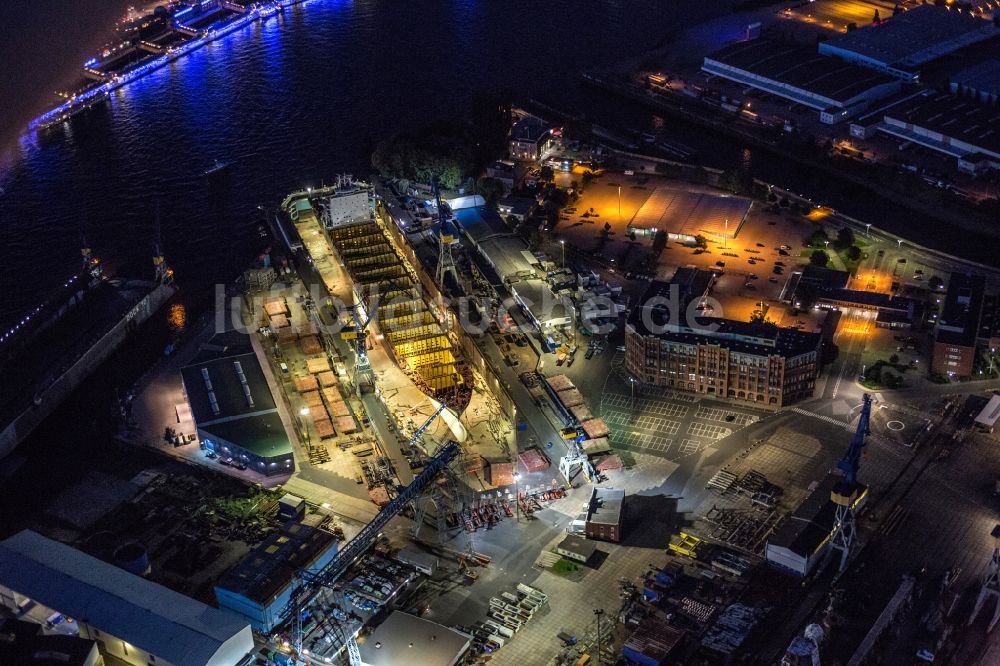 Hamburg bei Nacht aus der Vogelperspektive: Nachtluftbild Trockendock mit Schiffsrumpf auf dem Blohm und Voss Dock Elbe in Hamburg
