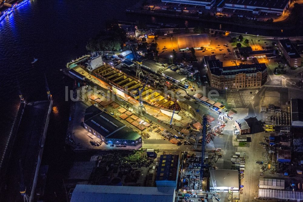 Nachtluftbild Hamburg - Nachtluftbild Trockendock mit Schiffsrumpf auf dem Blohm und Voss Dock Elbe in Hamburg