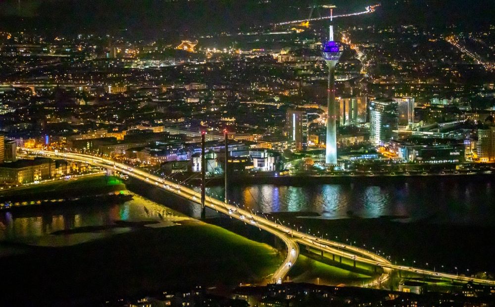 Nachtluftbild Düsseldorf - Nachtluftbild Uferbereiche am Rheinbogen im Bereich der Rheinkniebrücke mit Blick auf den Fernsehturm Rheinturm in Düsseldorf im Bundesland Nordrhein-Westfalen