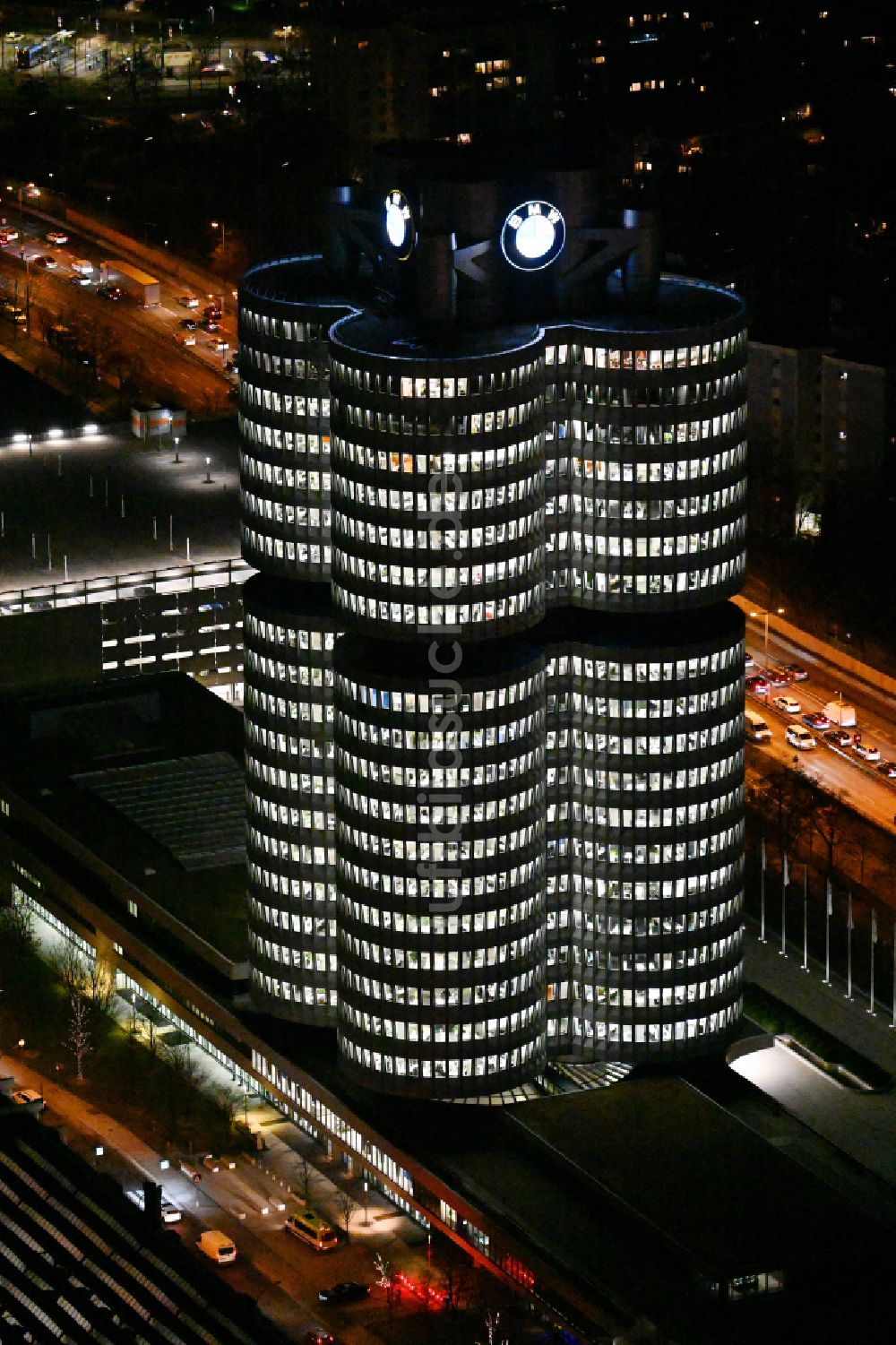 München bei Nacht von oben - Nachtluftbild Unternehmen- Verwaltungsgebäude Vierzylinder der BMW AG in München im Bundesland Bayern, Deutschland